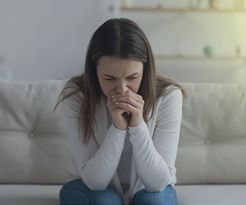 A woman sitting on a couch in deep thought